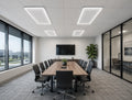 LED T-Bar frame lights installed in Modern conference room with a long table, chairs, and a large TV on the wall.
